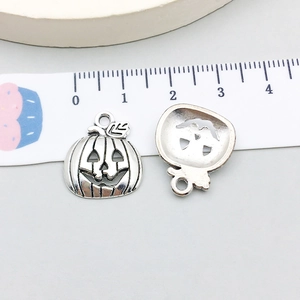 Macro detail of pumpkin pendants with antique silver finish and carved face texture