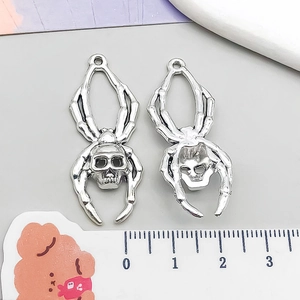 Macro detail of gothic spider skull alloy pendants with front and back views for DIY jewelry
