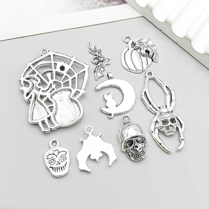 Macro detail of eight antique silver Halloween charms including spider, pumpkin and skull