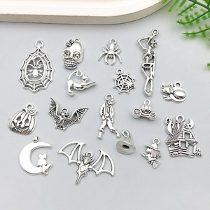 Macro detail of various vintage silver Halloween charms including skulls and bats