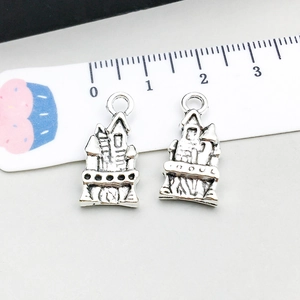 Macro view of vintage silver castle pendants with scale ruler showing 2cm size
