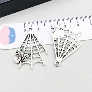 Antique silver spider web charms with scale ruler showing approximate 3cm height detail