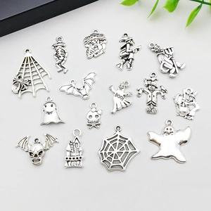 Macro view of vintage silver Halloween charms including spider webs and skulls
