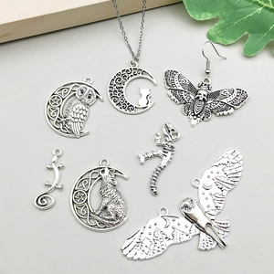 Detalle macro de colgantes de murciélago y lobo en plata vintage con relieves de aleación