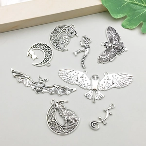 Detalle de los colgantes de murciélago y lobo en plata vintage para creación de joyas DIY