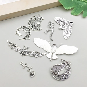 Detalle macro de colgantes de aleación plata antigua con diseños de murciélago y luna diy