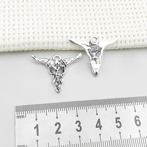 Macro detail of antique silver bull skull pendants showing both front and hollow back sides