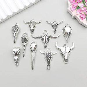 Macro view of antique silver bull and bird skull alloy pendants for DIY jewelry design