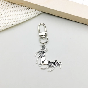 Macro view of gothic silver bat wing heart charm with cross detail and D-ring clasp