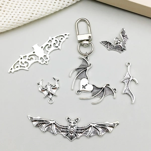 Detailed view of antique silver bat charms and heart keychain for DIY jewelry making