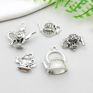 Detailansicht von fünf Vintage-Silber-Teekannen-Anhängern für Schmuck auf weißem Grund