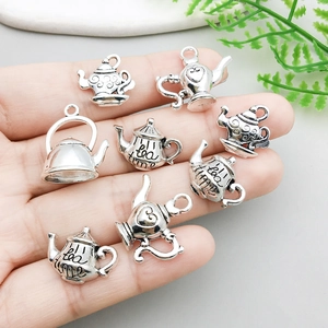 Vintage-Teekannen-Anhänger aus Silber mit Tea-Time-Gravur in der Hand für Schmuckzubehör