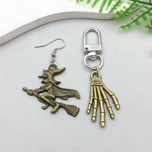 Detail of bronze alloy Halloween charms featuring witch on broom and skeleton hand