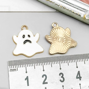 Detailed macro view of enamel ghost charm showing front white face and golden textured back