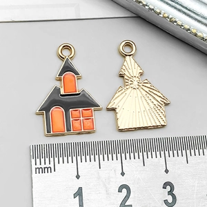 Macro detail of Halloween house charm showing enamel front and golden radiating texture back