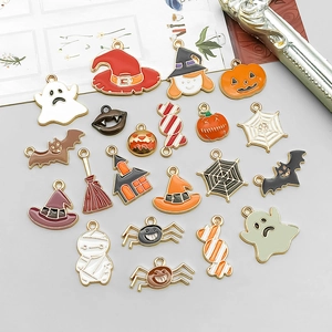 Flat lay of colorful Halloween alloy enamel charms with pumpkin, ghost, and witch hat motifs