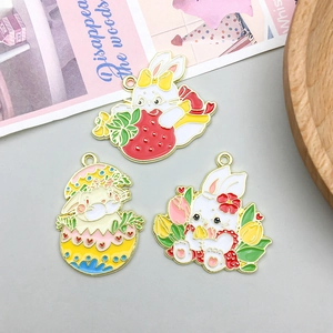 Macro shot of colorful enamel rabbit pendants with golden alloy borders and hooks