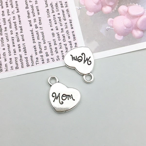 Macro shot of two heart-shaped Mom charms for DIY necklaces with vintage alloy finish