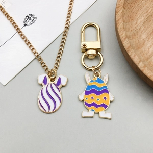 Detailed view of colorful enamel Easter egg pendants on gold necklace and keychain set