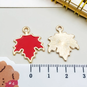 Makroaufnahme von roten Ahornblatt-Anhängern aus Legierung für DIY-Schmuck mit Goldplattierung