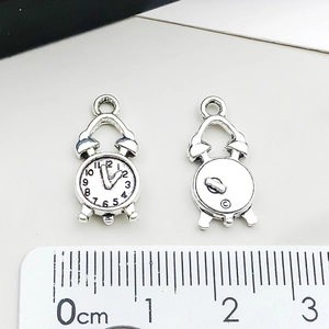 Vue macro d'un pendentif horloge en argent antique avec une échelle sur fond blanc