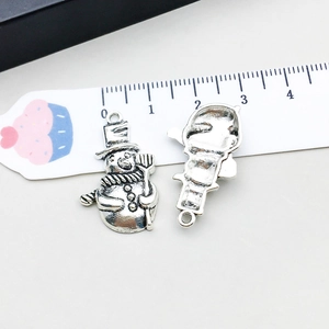 Detail of antique silver snowman charms with hats and shovels for DIY jewelry making