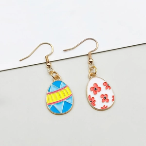 Detailed macro of colorful Easter egg enamel pendant earrings with floral and stripe patterns