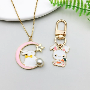 Close-up of gold enamel rabbit and moon pendants with pearls and rhinestones on a tray