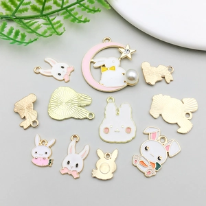 Detailed view of enamel Easter bunny charms with pearls and golden moon pendants