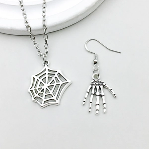 Detail van zilveren spinnenweb ketting en skelet hand oorbel voor Halloween sieraden DIY