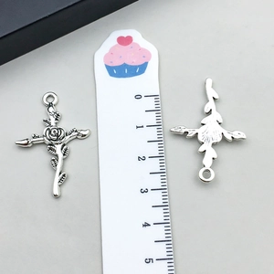 Détail macro d'un pendentif croix rose en argent vintage de 4,3 cm avec relief