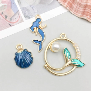 Detailweergave van blauw geëmailleerde schelp en zeemeermin hangers voor DIY sieraden