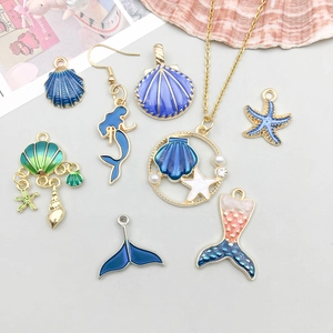 Detailweergave van blauwe emaille oceaanhangers met schelpen, zeesterren en zeemeerminnen
