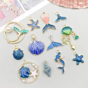 Blauwe emaille hangers met schelpen zeesterren en zeemeerminnen in goud