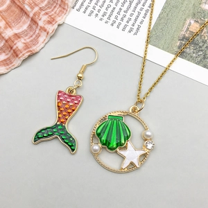 Detail of green shell necklace and mermaid tail earrings with pearl and starfish decor