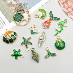 Detail of green enamel ocean charms including starfish and shells for DIY jewelry making
