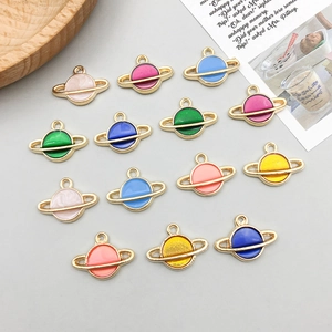 Détail de breloques planètes Saturne colorées avec bords dorés et émail pour bijoux DIY