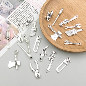 Gros plan de pendentifs outils en alliage argent antique pour la création de bijoux