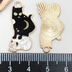 Detail of Gothic Halloween cat and skull alloy pendant with golden texture on reverse side