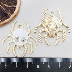Detail of spider charms with skull design, moving eyes and gold metal textured back