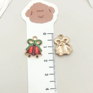 Macro view of Christmas red bell charm with green bow for DIY jewelry making projects