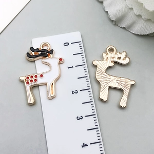 Detail of Christmas elk pendant with white enamel finish and golden textured metal back