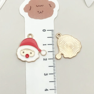 Detail of Santa Claus enamel charm showing both sides and dimensions with a ruler
