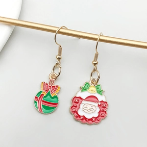Detail of Christmas themed asymmetrical drop earrings with Santa and green ornament