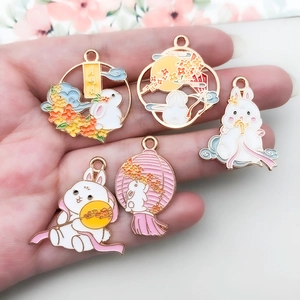 Handheld view of five Mid-Autumn rabbit enamel charms with gold alloy drip oil details