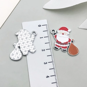 Detalle de colgantes de Papá Noel mostrando esmalte colorido y reverso de metal