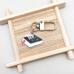 Detail of gothic enamel book keychain with pentagram pattern and silver metal hook