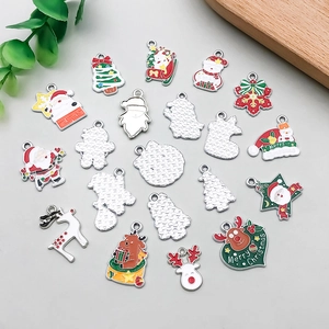 Detalle de dijes navideños de esmalte de colores mostrando el frente y el reverso plateado