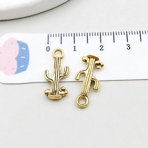 Macro view of vintage bronze cactus charms for DIY jewelry making with metric scale ruler