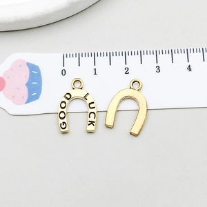 Detail of horseshoe lucky charm pendant in antique gold with GOOD LUCK engraving